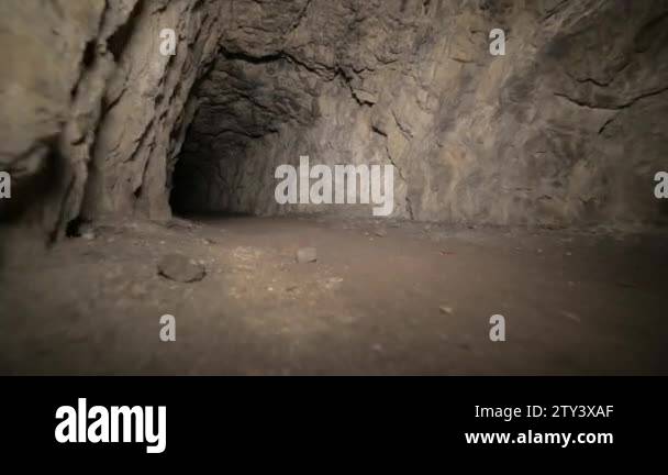 Speleology artificial cave dark tunnel excavation underground. Old adit ...