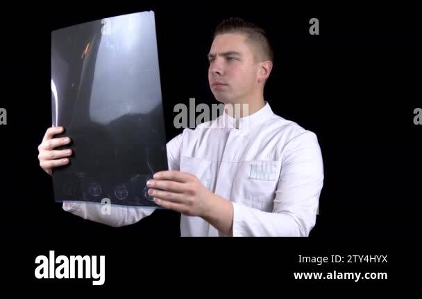 A young man doctor checks the results of an MRI scan of a spine. A man ...