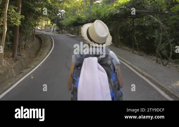 Rear back view of asian female hiker walking with backpack through ...