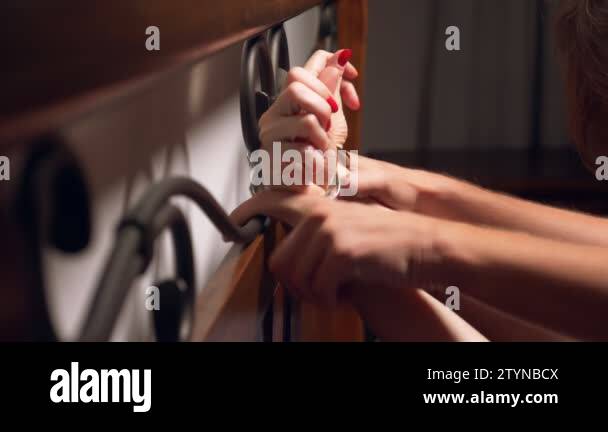 BDSM, sex toys. romantic couple in bed. the hands are handcuffed to the  wrought headboard. close-up, details