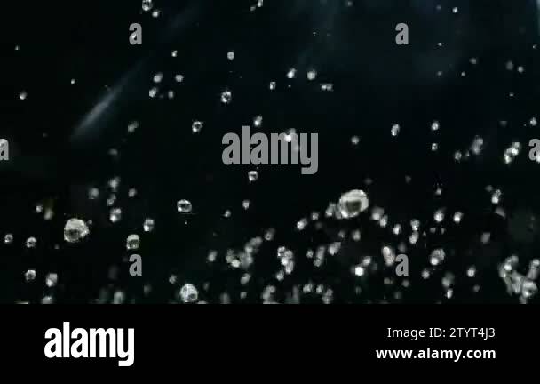 Water droplets rise in the air against Black Background. Slow motion ...