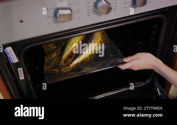 Cooking whole roasted fish with marinade baked in the oven. Woman chef