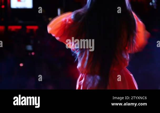On Stage Back View Rapper Girl who sings and dances on stage, Back view of singer. Light and ...