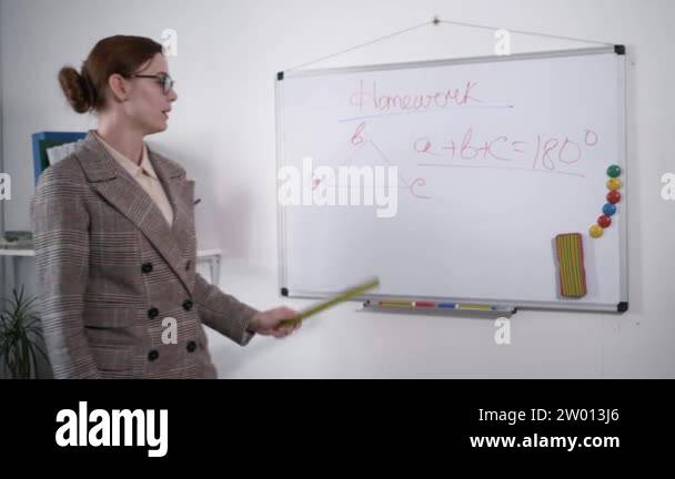 schoolchildrens education, young female teacher with ruler in hands ...