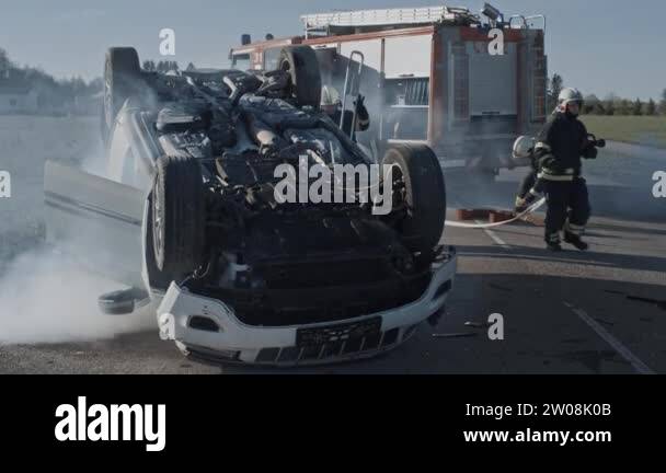 Traffic Accident Rollover Smoking And Burning Vehicle Lying On Its Roof ...