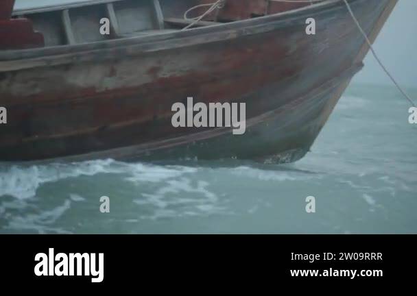 Closeup boat bow drifting in the wavy sea over cloudy dark sky ...