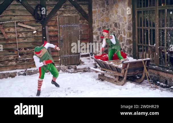 Elf Playing Couple of elves are playing snowballs running around a backyard ...