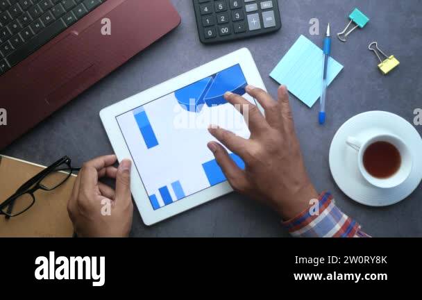 man hand analyzing charts on digital tablet, using self created chart ...