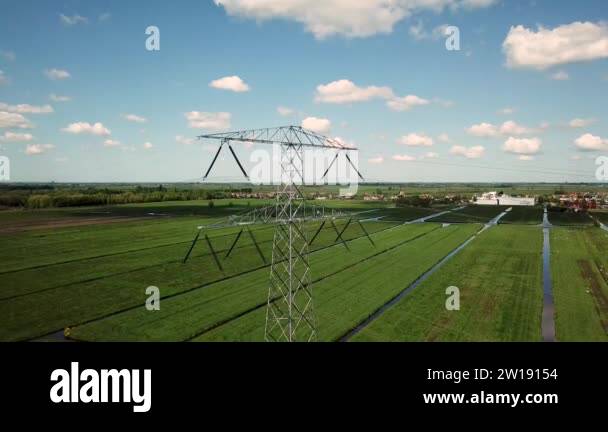 High voltage pylons with green fields electrical poles with blue sky ...