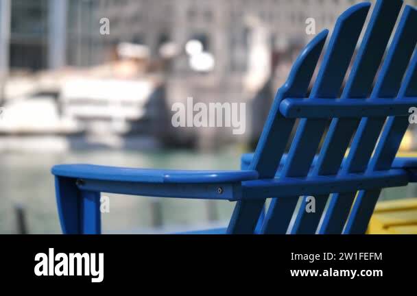 Close up slow motion panning clip of two blue and yellow lawn chairs ...