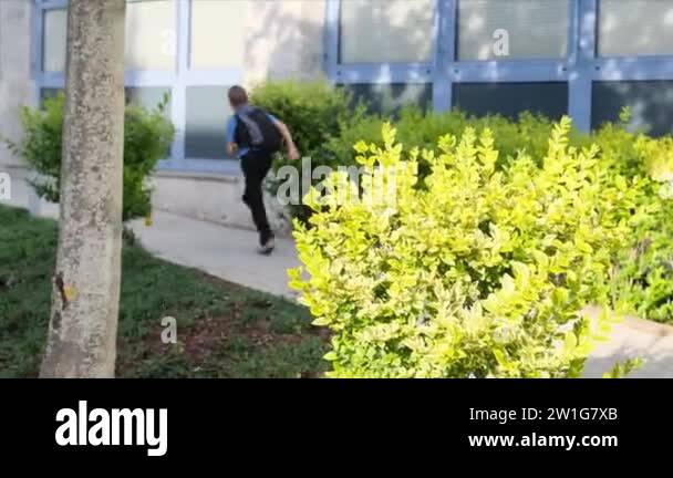two boys, schoolchildren in black school uniforms with backpacks go to ...