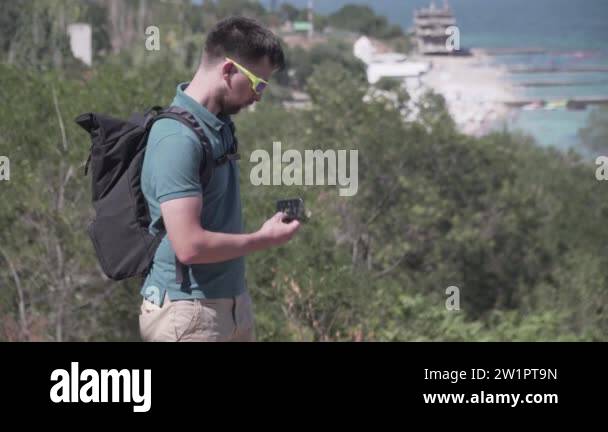 Man navigates use smartphone while day hiking using GPS device on a ...