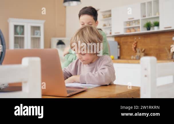 Two boys do homework. Older brother helps the younger one with homework ...