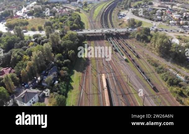 Aerial moving right above railway hub showing passenger trains on ...