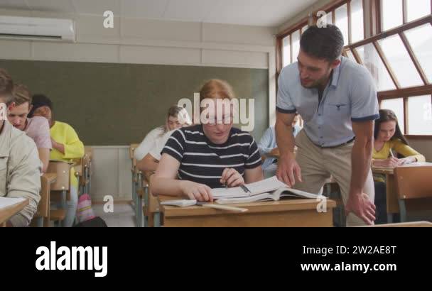 Front view of a Caucasian male school teacher, standing and talking ...