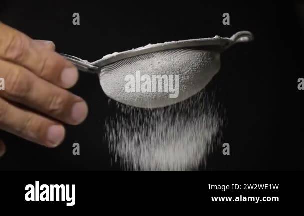 Close-up of flour through a sieve fray. Sifting flour baking. Slow ...
