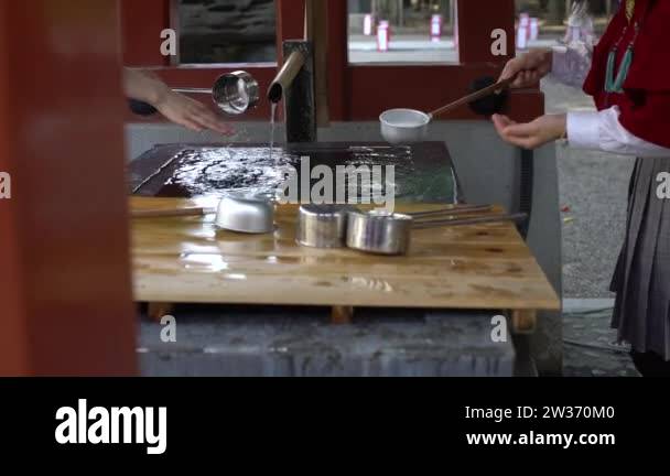 4K Religious people washing hands in shinto water ablution pavilion for ...