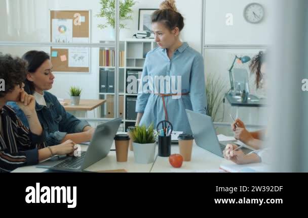 Angry Asian woman yelling at multi-ethnic group of employees talking ...