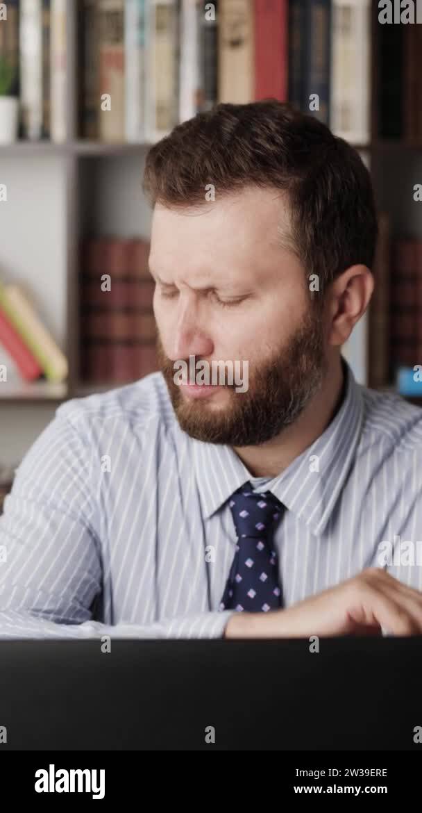 Pain in elbow. Vertical orientation of bearded man at computer