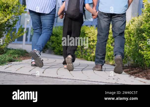 two boys, schoolchildren in black school uniforms with backpacks go to ...
