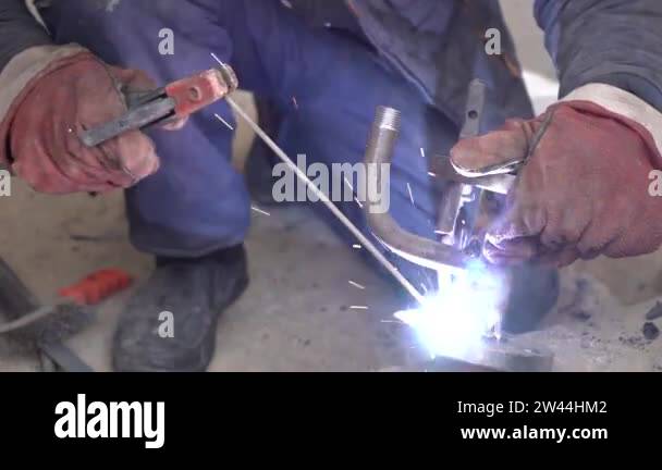 Close-up welder working with electrode at semi-automatic arc welding in ...