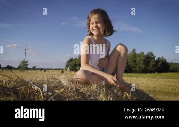 cute little girl sits on mown rye in the field Stock Video Footage - Alamy