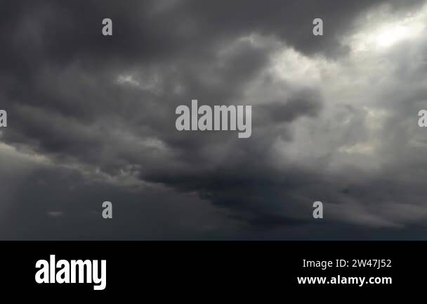 Feathery gray storm clouds churn and begin to dissipate in the overcast ...