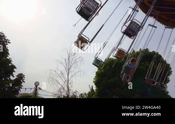 carousel of chain is spinning in amusement Park. girls ride swing at ...
