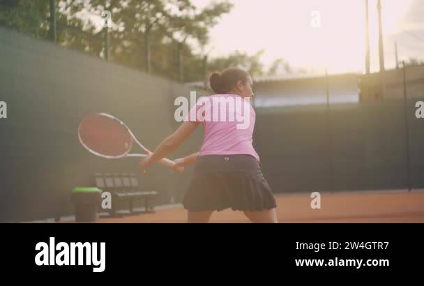 Professional equipped female beating hard the tennis ball with tennis ...