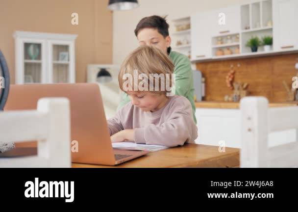 Two boys do homework. Older brother helps the younger one with homework ...