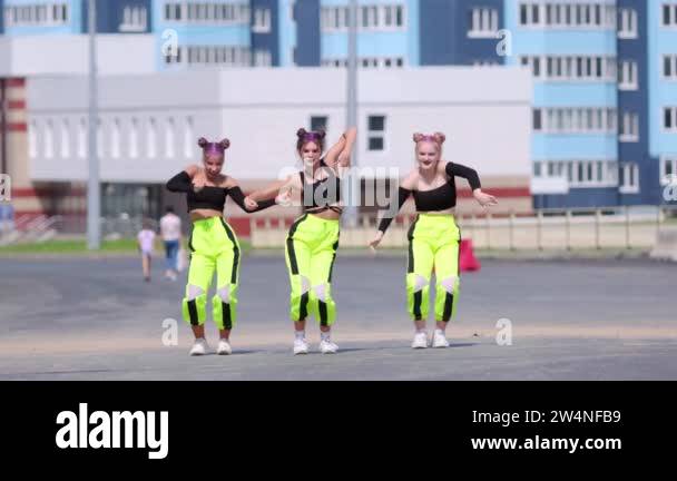 Three young beautiful girls dance free style street dancing, hip hop ...