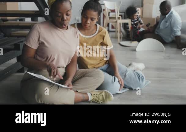 Tilt up slowmo of African-American woman and girl sitting together on ...