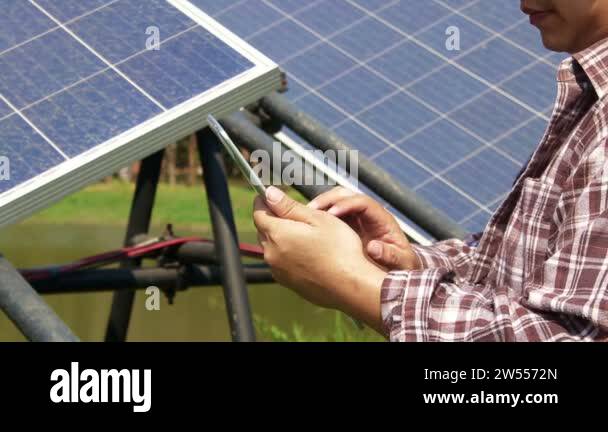 Tablet Using Solar Panel farming man holding a tablet Used to control solar panels, solar power ...