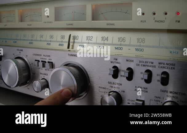 Vintage radio receiver and amplifier with fm scale. Male hand tune ...