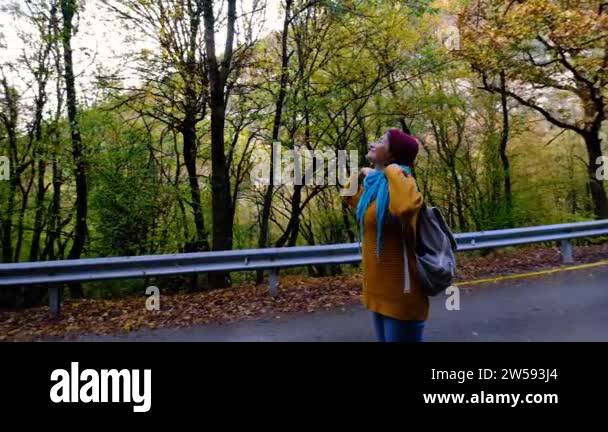 Young woman resting after a walk in the forest, carrying a backpack in ...