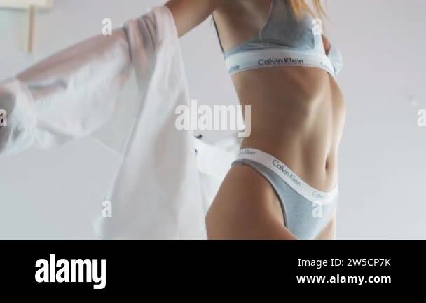 TOMSK, RUSSIA - August 16, 2020: Sexy blonde girl in calvin klein underwear  and shirt on the bed. Portrait shoot