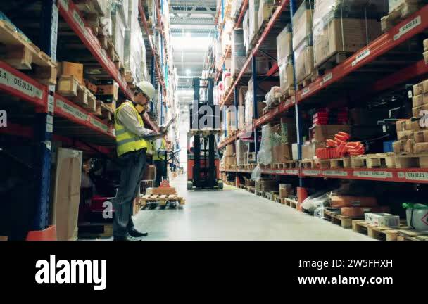 Engineers are watching the loading vehicle in the warehouse Stock Video ...