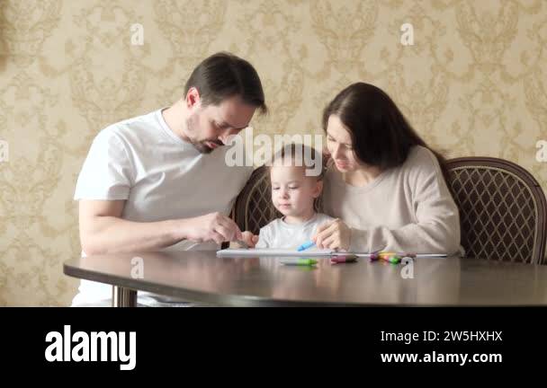 Mom, dad, child, daughter draw together childs drawing at home. A ...