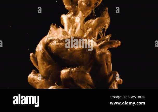 Golden ink in water shooting with high speed camera. Gold drops of ...