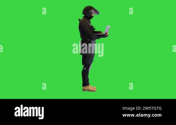 Masked Police Officer Using a Laptop Computer on a Green Screen, Chroma ...