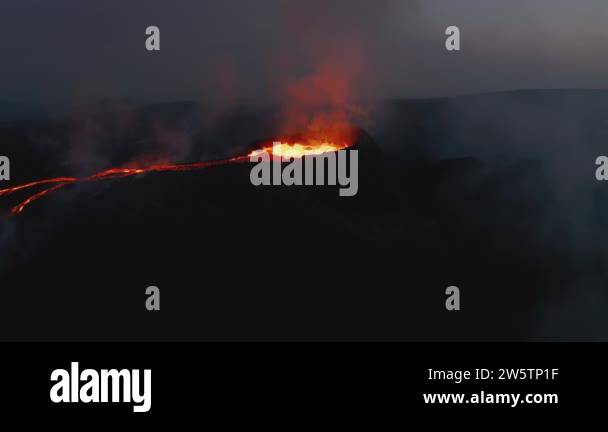 Panoramic view of volcano eruption at night. Magma gushing in crater ...