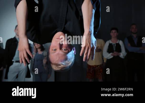 Man hanging upside down with open hands, symbolizing the struggle of pretending to be patient