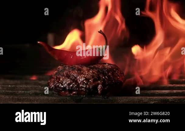 Juicy meat for Burger with red chili pepper is fried on coals on grill ...