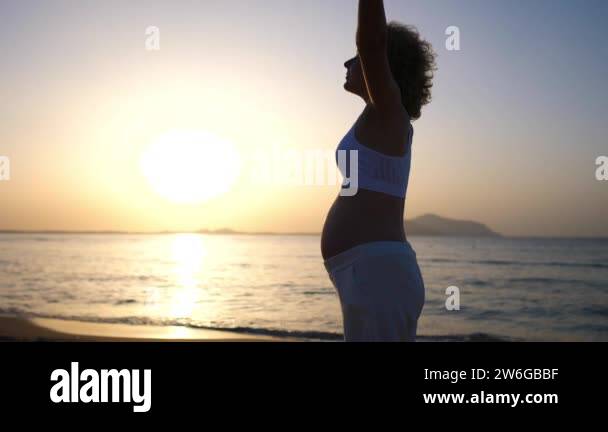 Happy maternity leave on beach. White pregnant woman practicing