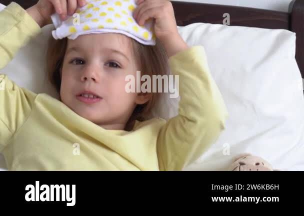 close up Authentic cute little sick preschool child girl puts compress ...