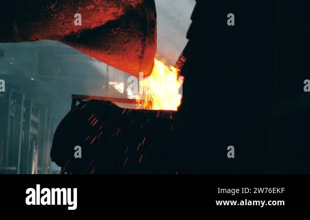 Molten metal is pouring from industrial tank with sparks Stock Video ...