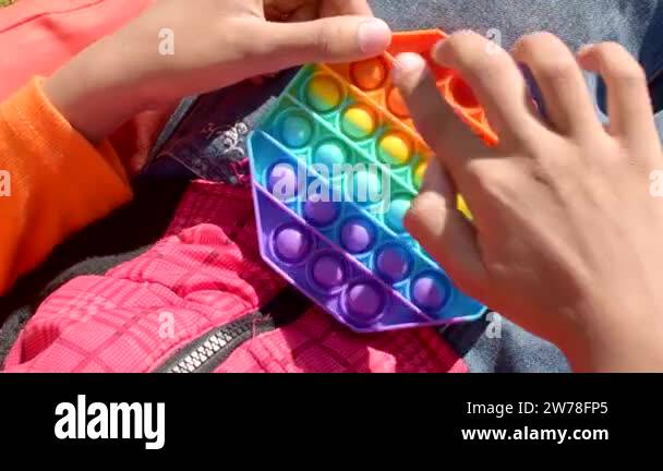 Colorful antistress sensory toy fidget push pop it in kids hands. Pop ...