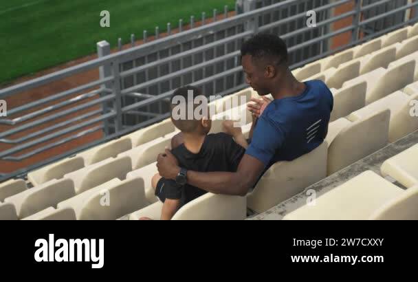 Diverse father and son hugging and watching match on stadium Stock ...