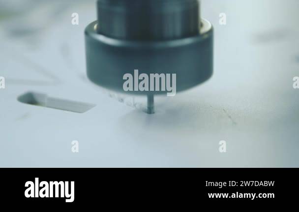 A machine processing factory workplace. The plastic workpiece is being ...