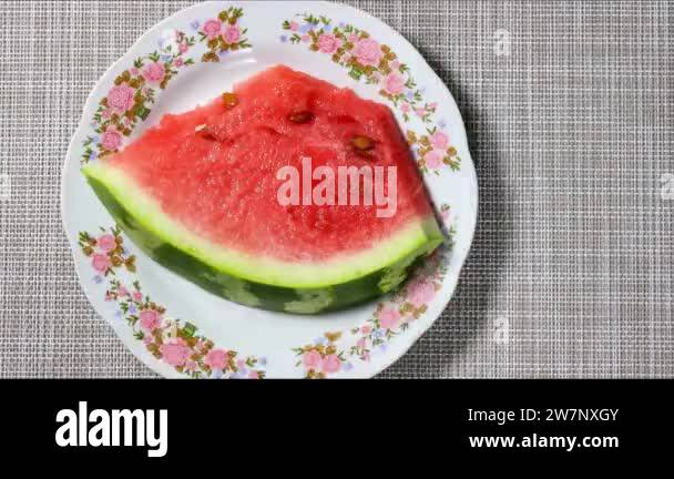 Stop motion animation. A piece of ripe watermelon on a plate, which is ...
